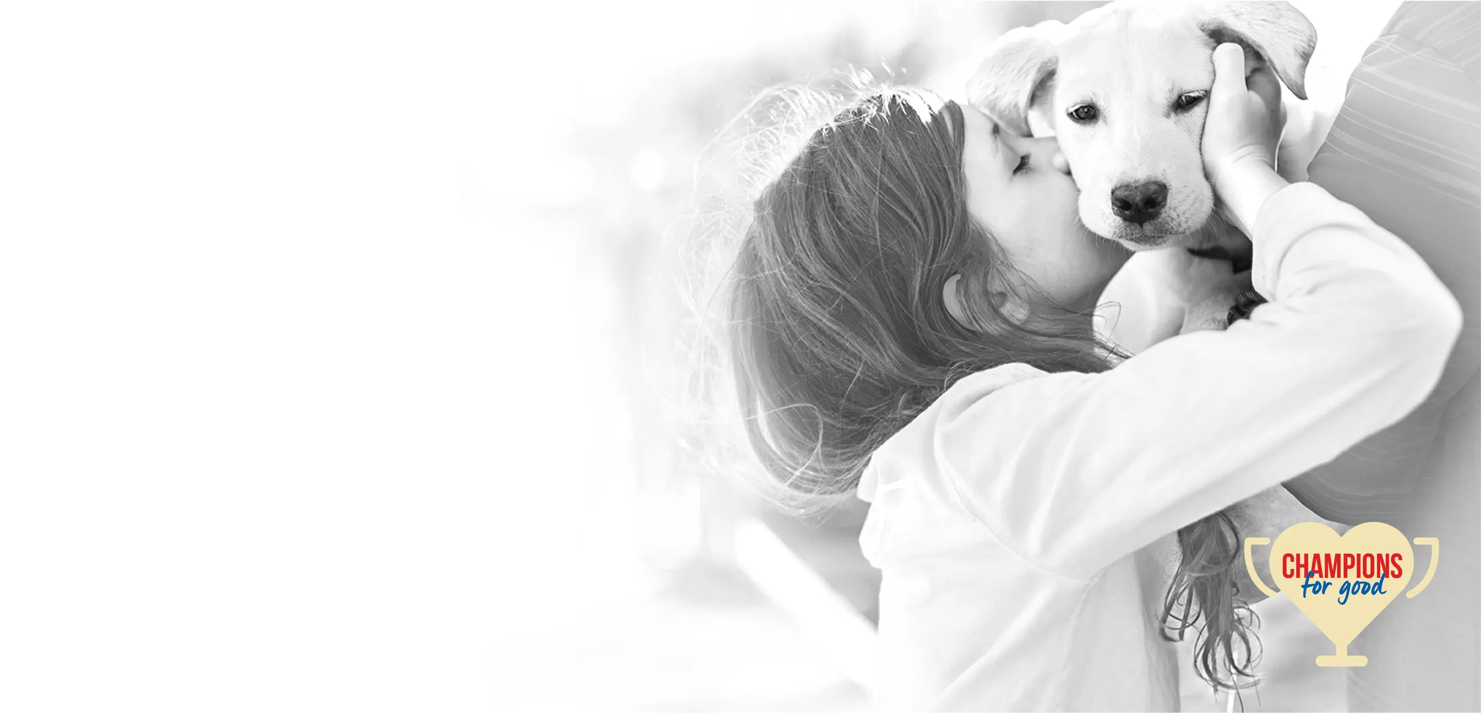 young girl kissing a dog on the side of his face, trophy icon that reads "Champion for Good"